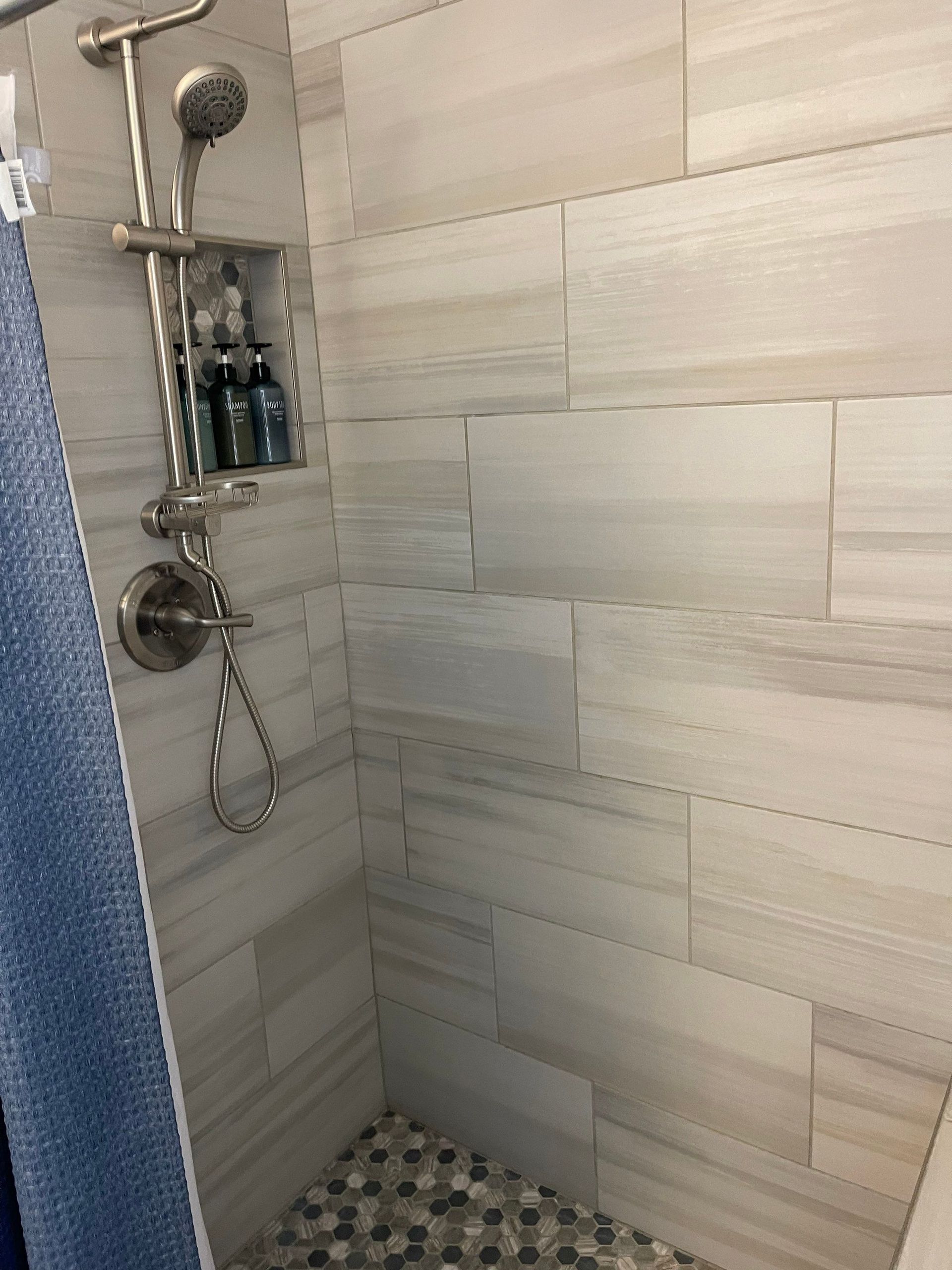 A shower with a shower head and a shower curtain.