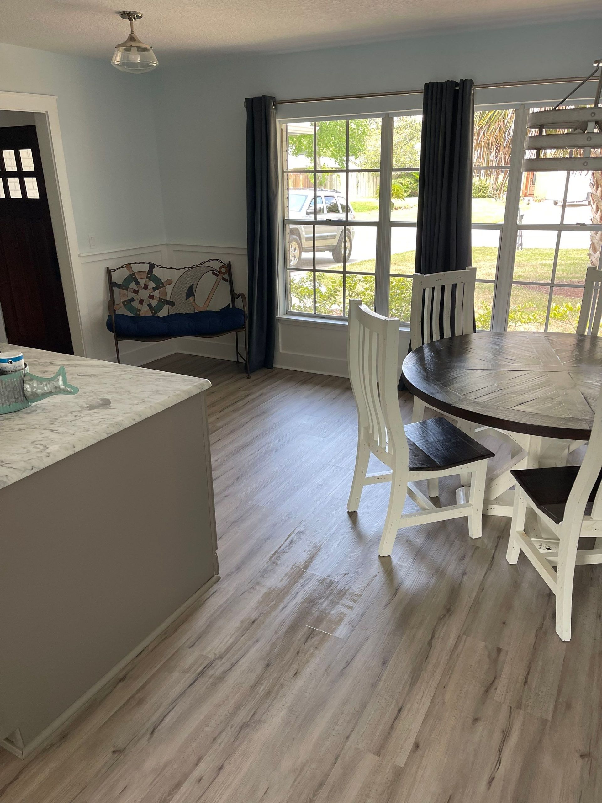 A dining room with a table and chairs and a bench.