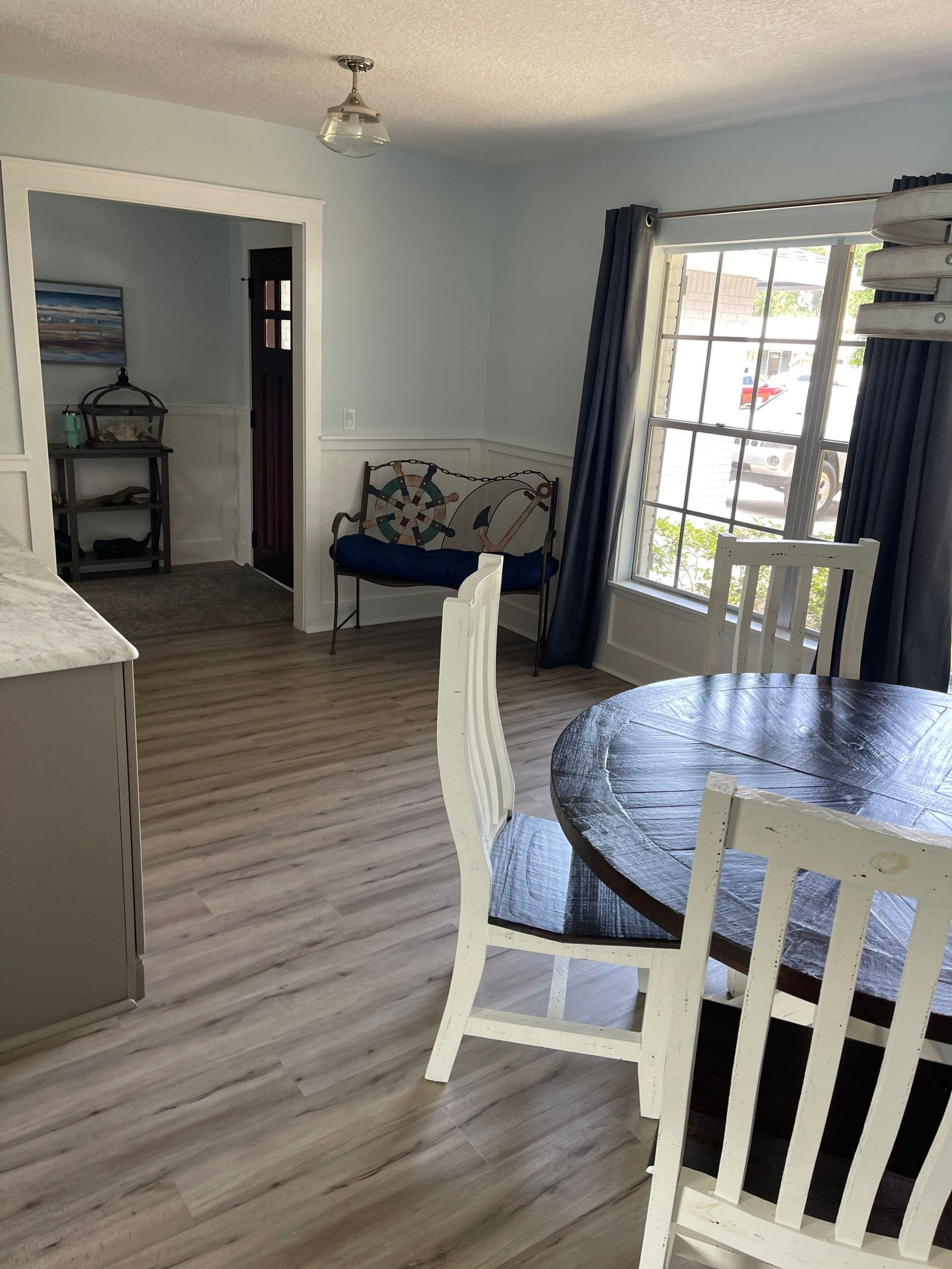 A living room with a table and chairs and a bench.
