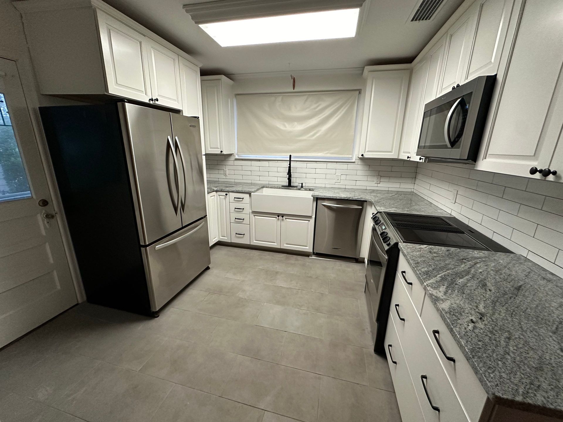 A kitchen with white cabinets and stainless steel appliances