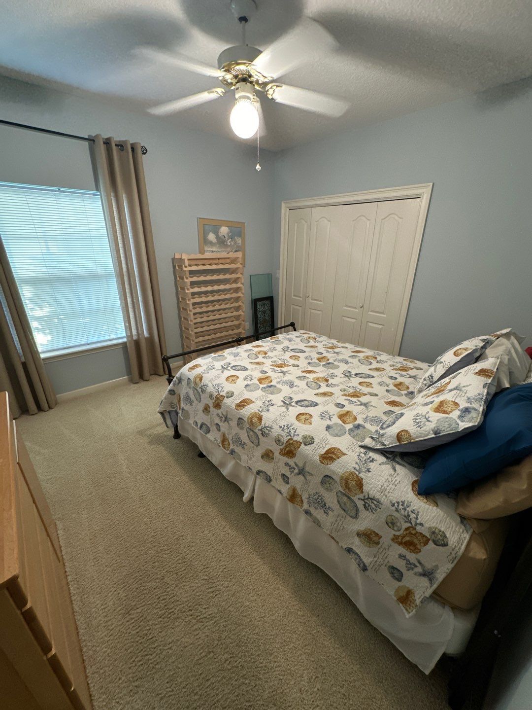 A bedroom with a bed and a ceiling fan.