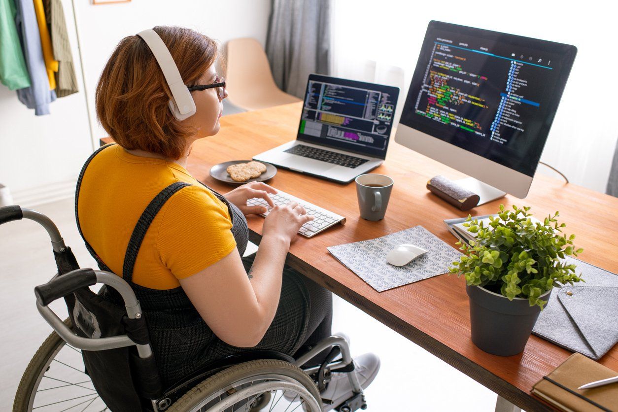Jovem cadeirante estudando online de casa para o bootcamp da XP Educação