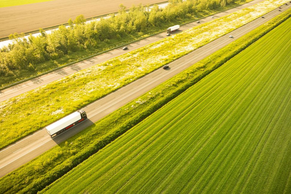 Un camion bianco sta percorrendo un'autostrada.