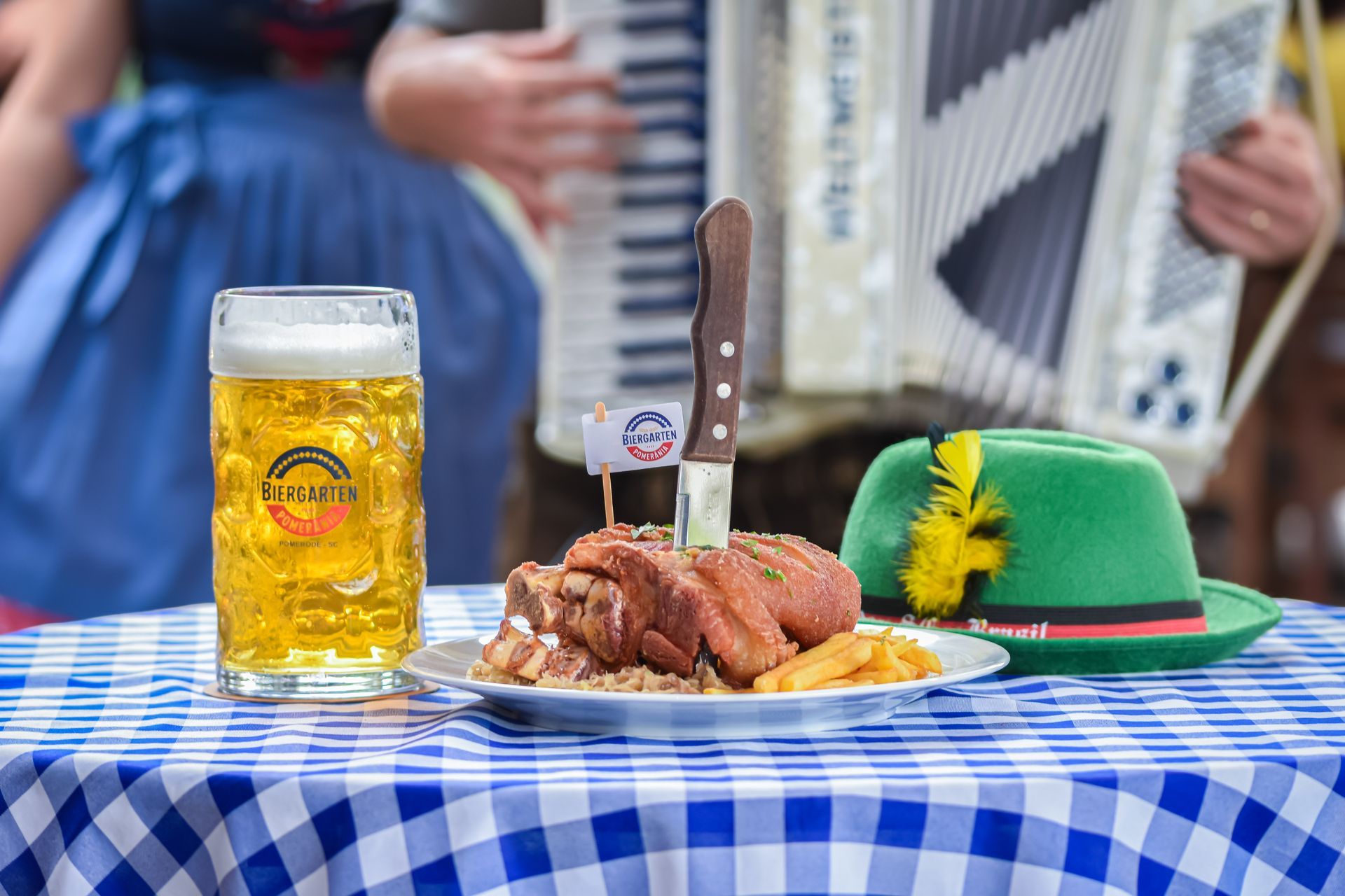 A table with a plate of food and a glass of beer on it.