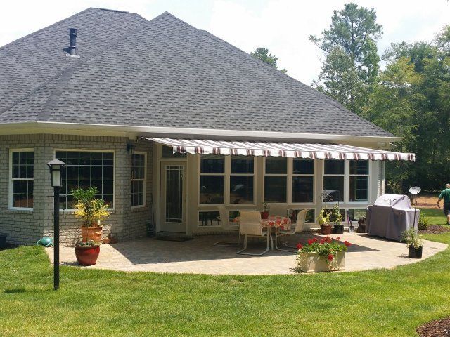 Handmade Retractable Awnings — House with Retractable Striped Awning in Spartanburg, SC