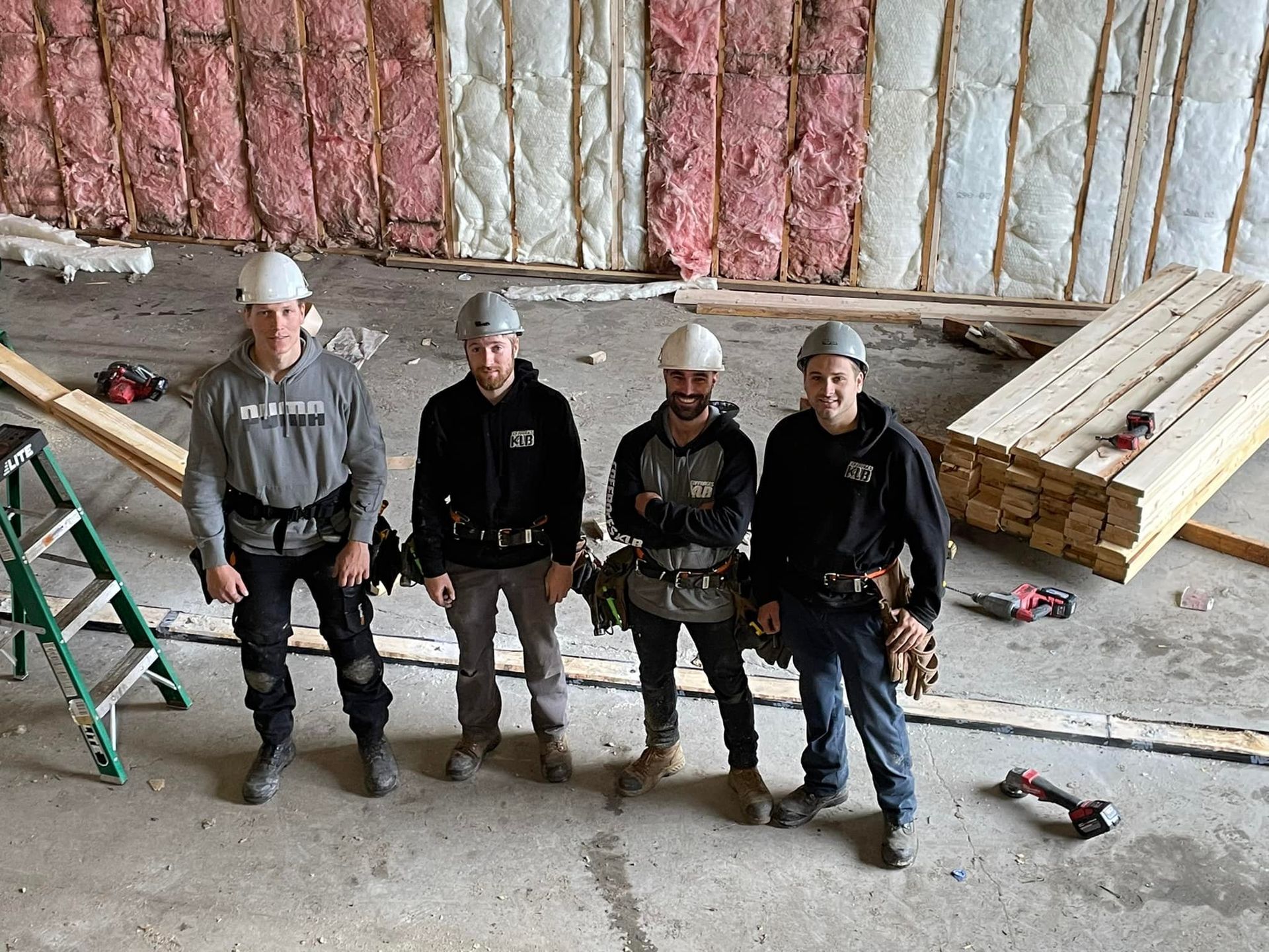 Un groupe d'ouvriers du bâtiment pose pour une photo dans un bâtiment en construction.