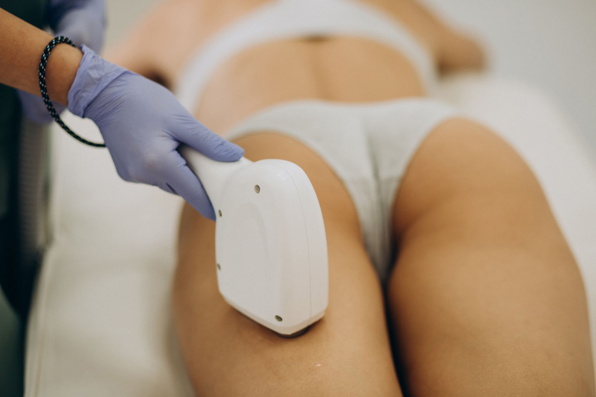 A woman is getting a laser hair removal treatment on her leg.