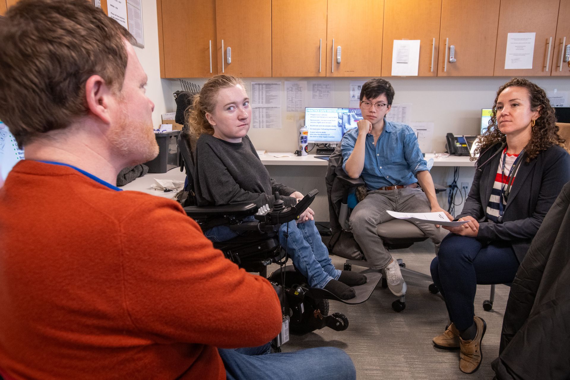 A group of people are sitting in a circle in a room