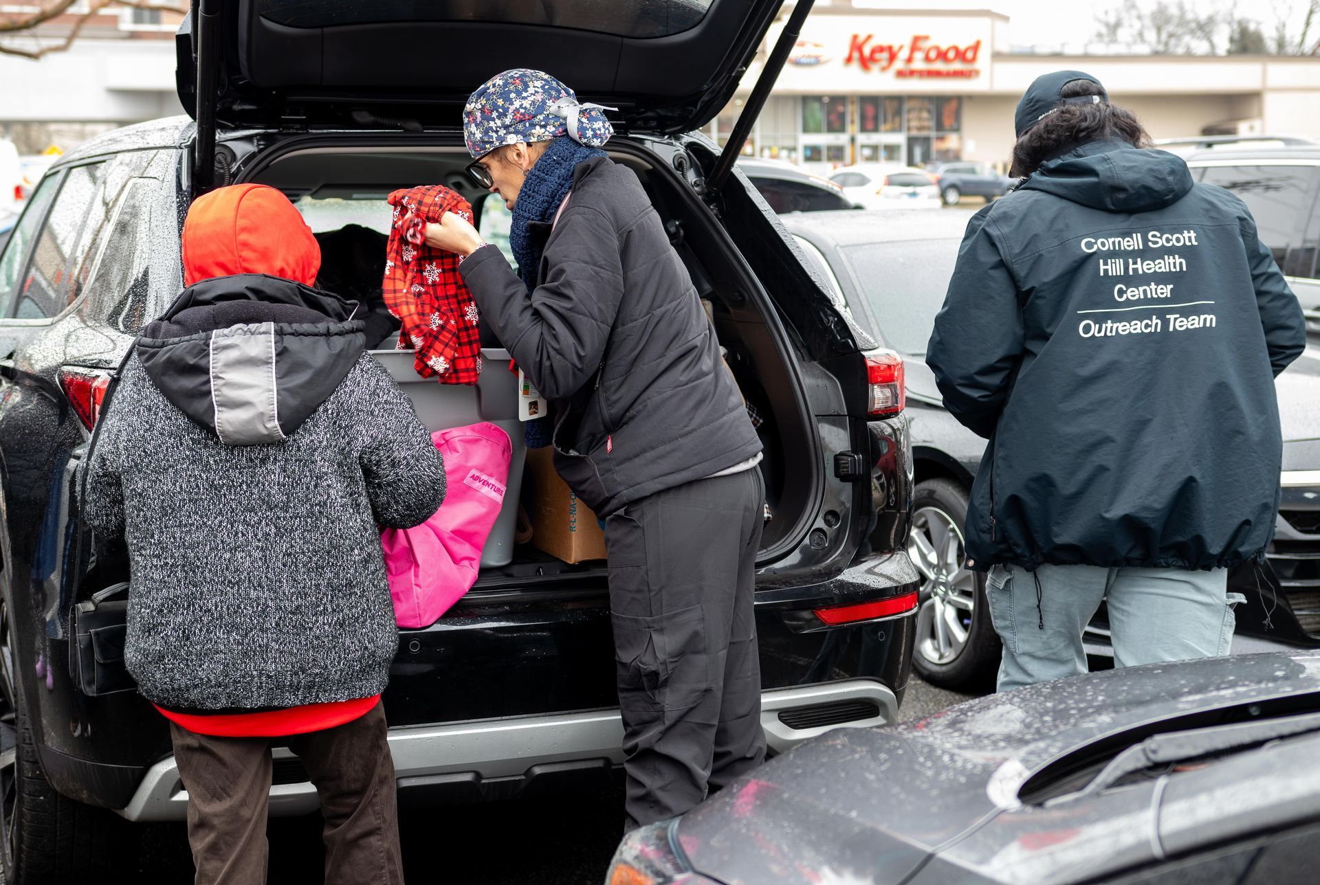 Outreach team employees taking items out of a car