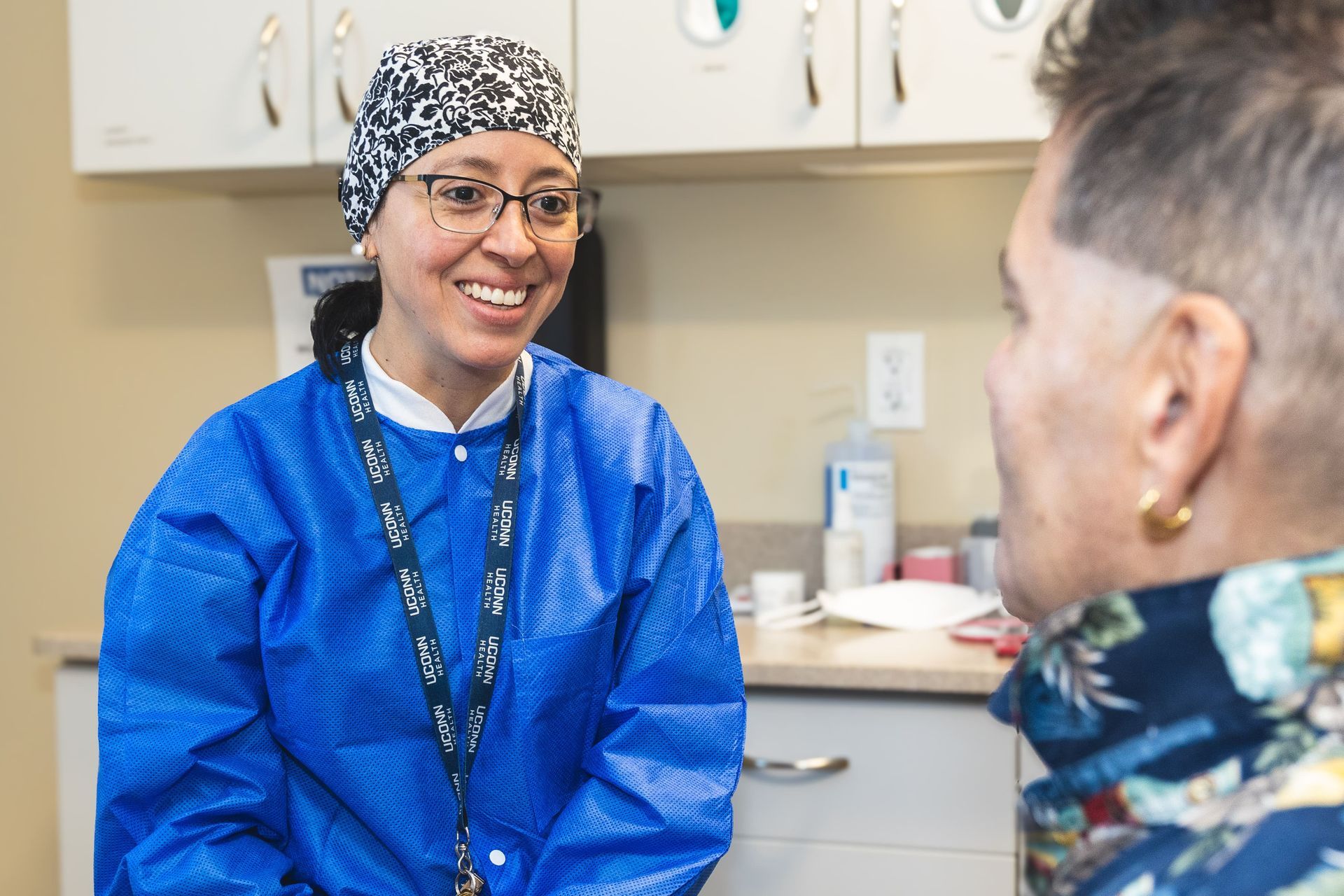 An image of a dentist smiling while looking at a patient