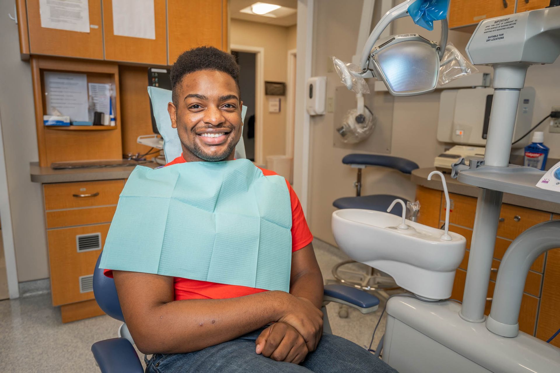 An image of a dental patient smiling and sitting in exam chair