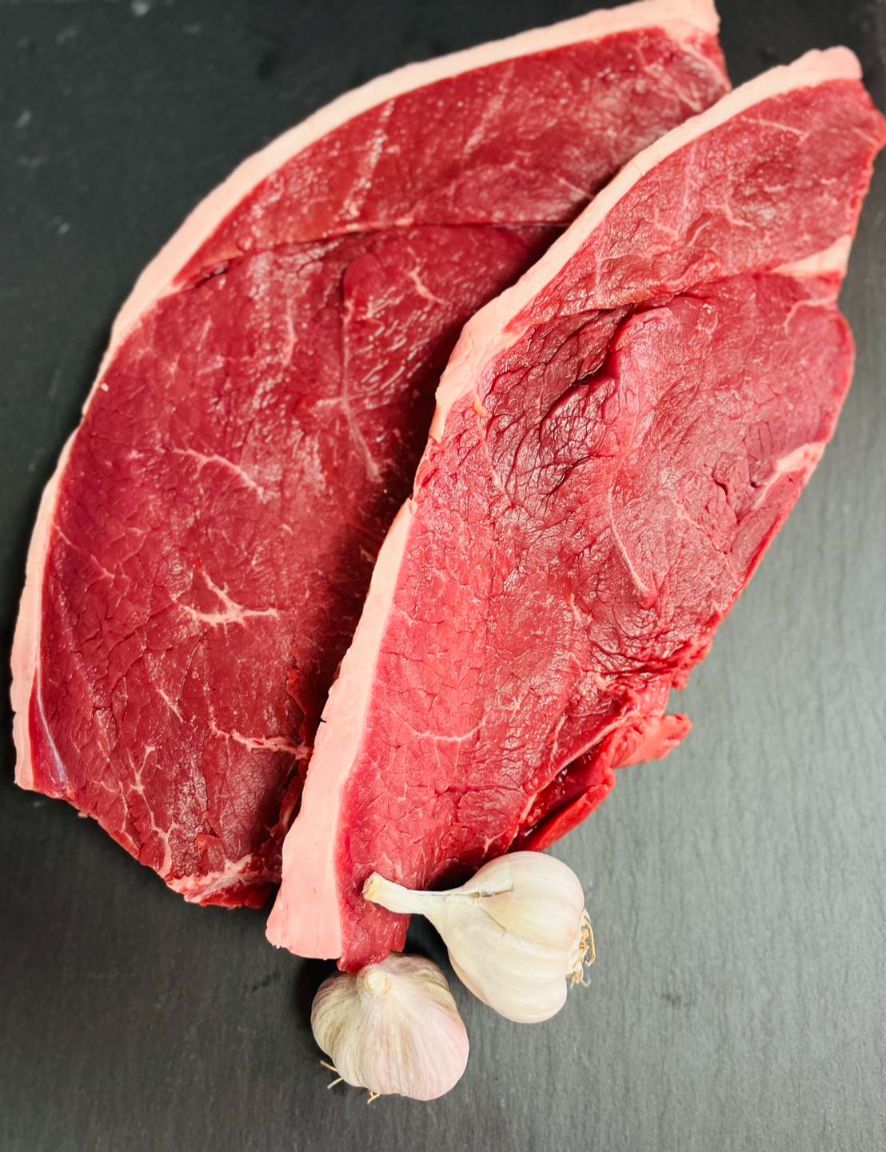 Two Steaks and Garlic on a Black Surface — MC Butchery in Moranbah, QLD