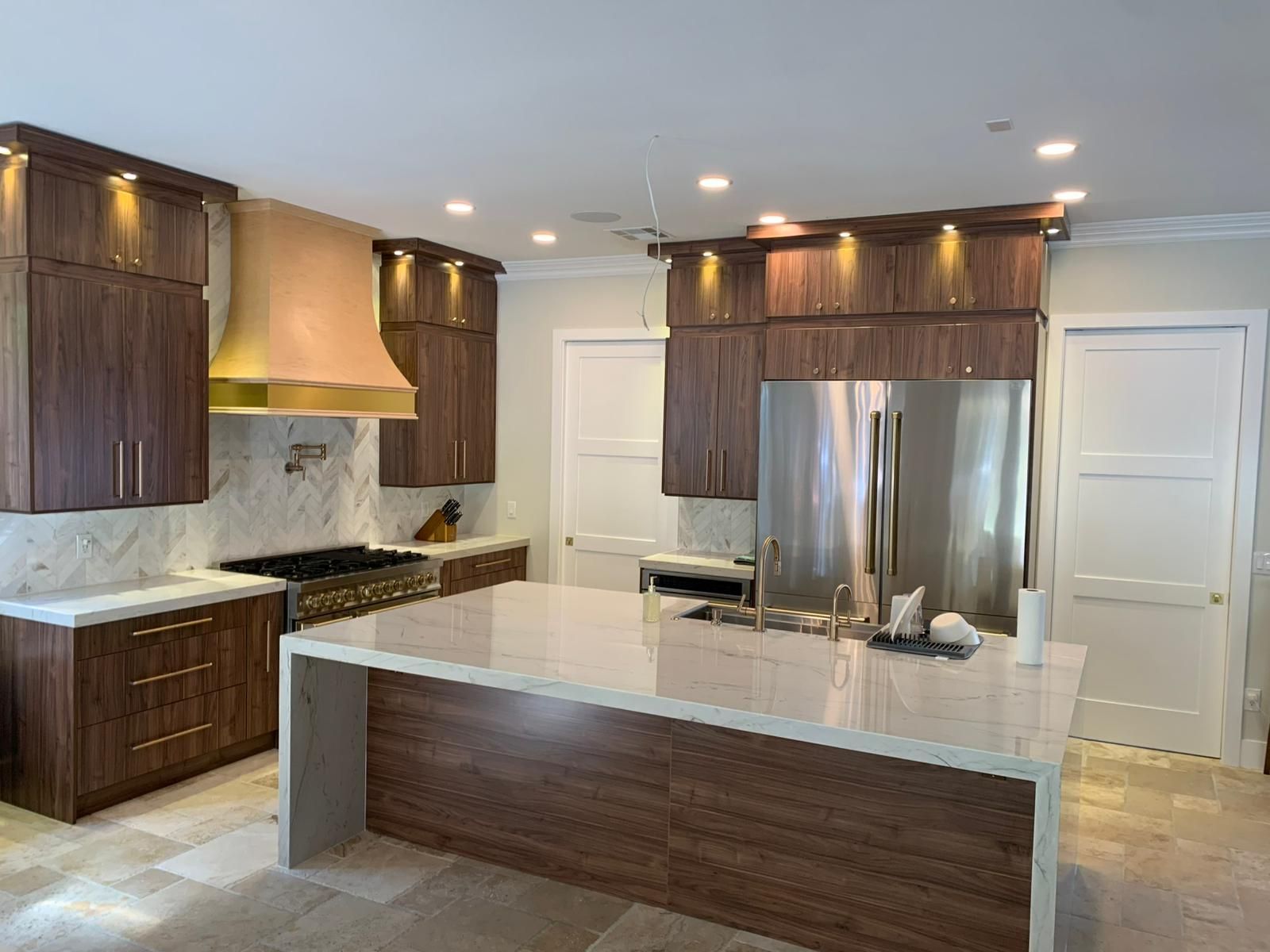 Kitchen with white marble countertop and wood cabinets. 