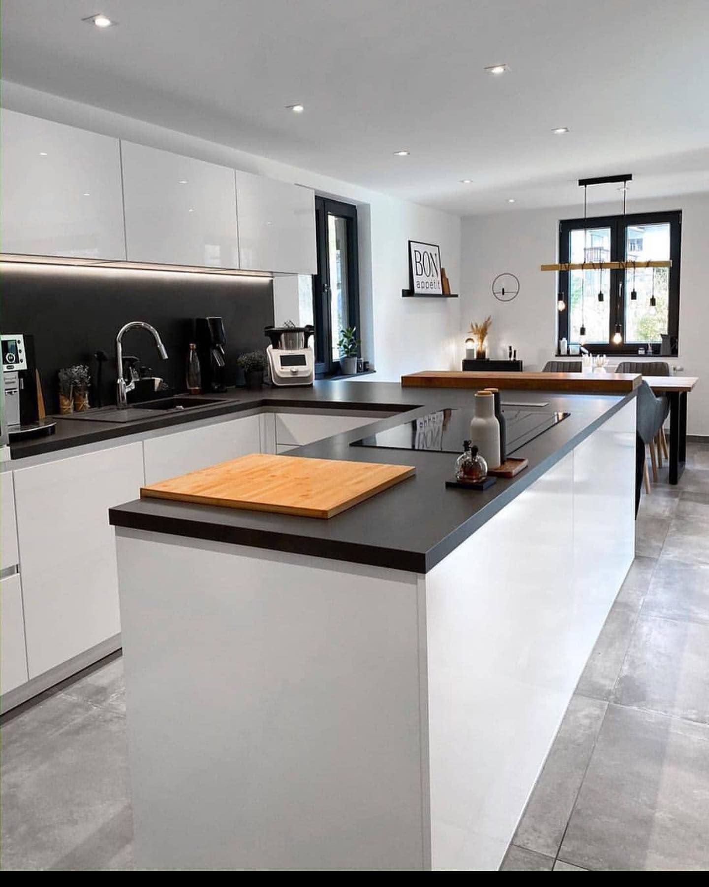 Contemporary kitchen for multi living featuring a black countertop, white cabinetry.