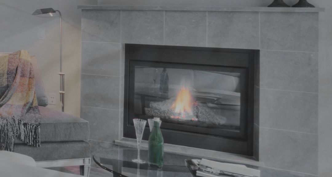 There is a fireplace in the living room with a bottle of champagne on the table.