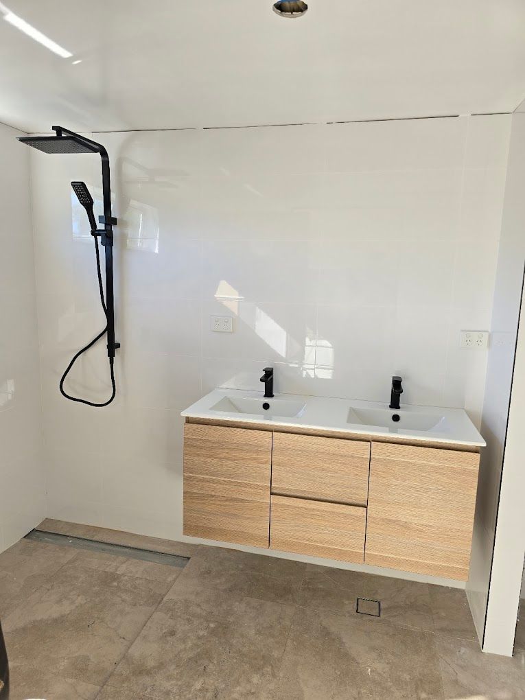 A Drill Is Sitting On A Tiled Floor Next To A Drill Bit — Country 2 Coast Plumbing And Gas In Wauchope, NSW