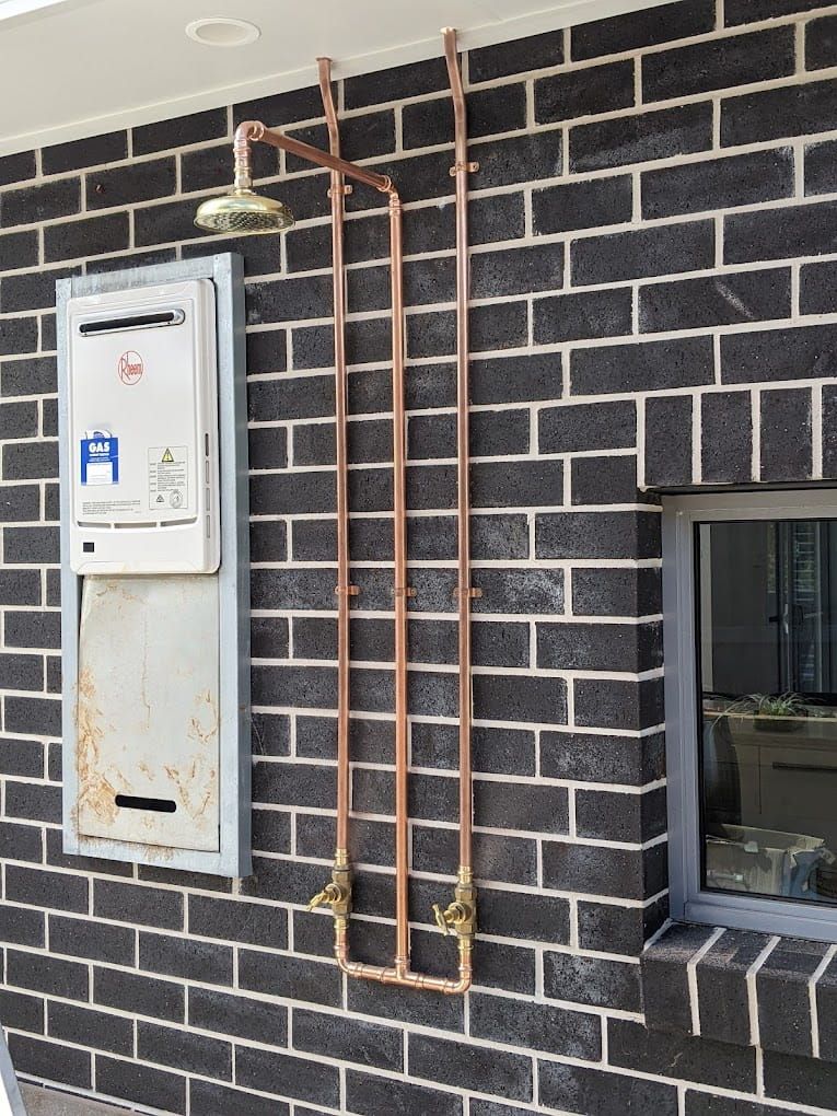 A Brick Wall With A Hose Attached To It — Country 2 Coast Plumbing And Gas In Wauchope, NSW