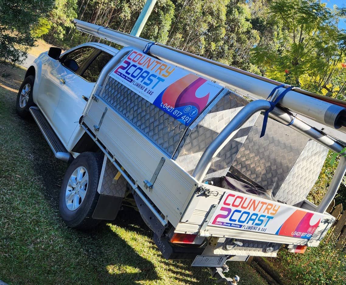 A Small House Is Being Built In The Middle Of A Grassy Field — Country 2 Coast Plumbing And Gas In Wauchope, NSW