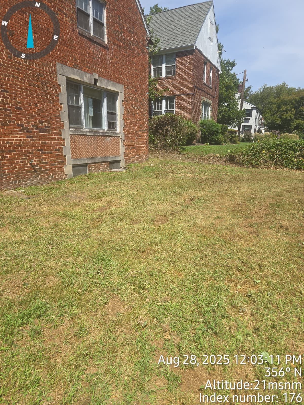Red brick buildings with a grassy yard.