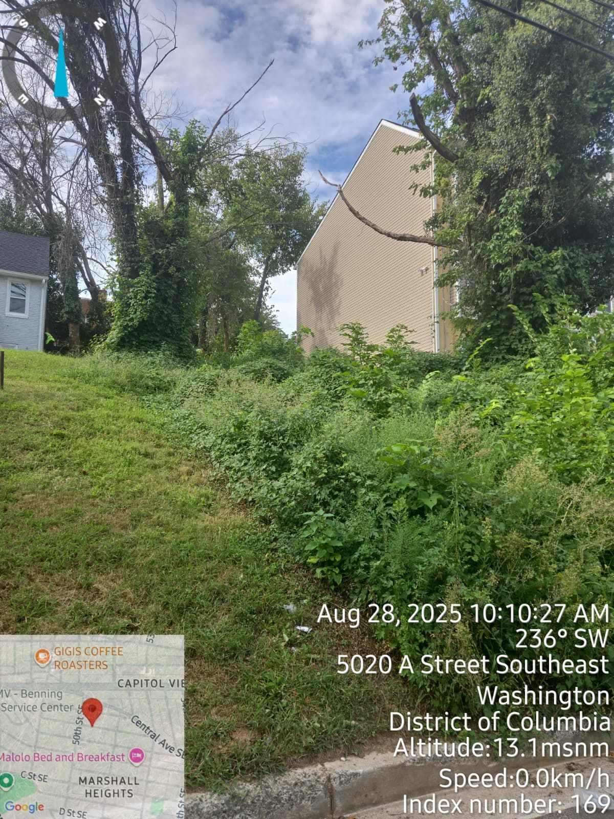 Grassy, overgrown lot on a slope; a building is visible in the background, location marked: 5020 A Street Southeast, Washington, DC.
