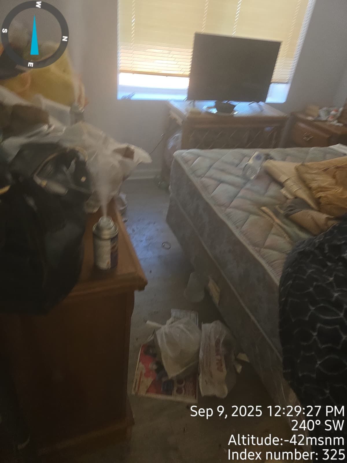 Messy bedroom with bed, nightstand, and window. Shows time, compass direction, and altitude.