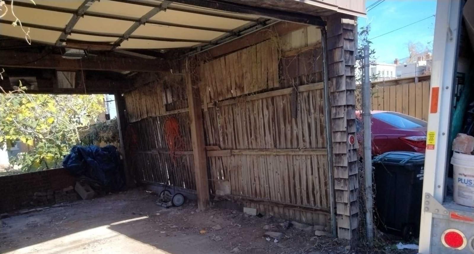 A truck is parked in a garage with the door open.