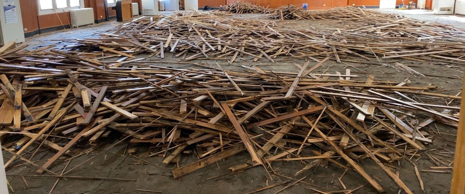 A large pile of wood is sitting on the floor in a room.