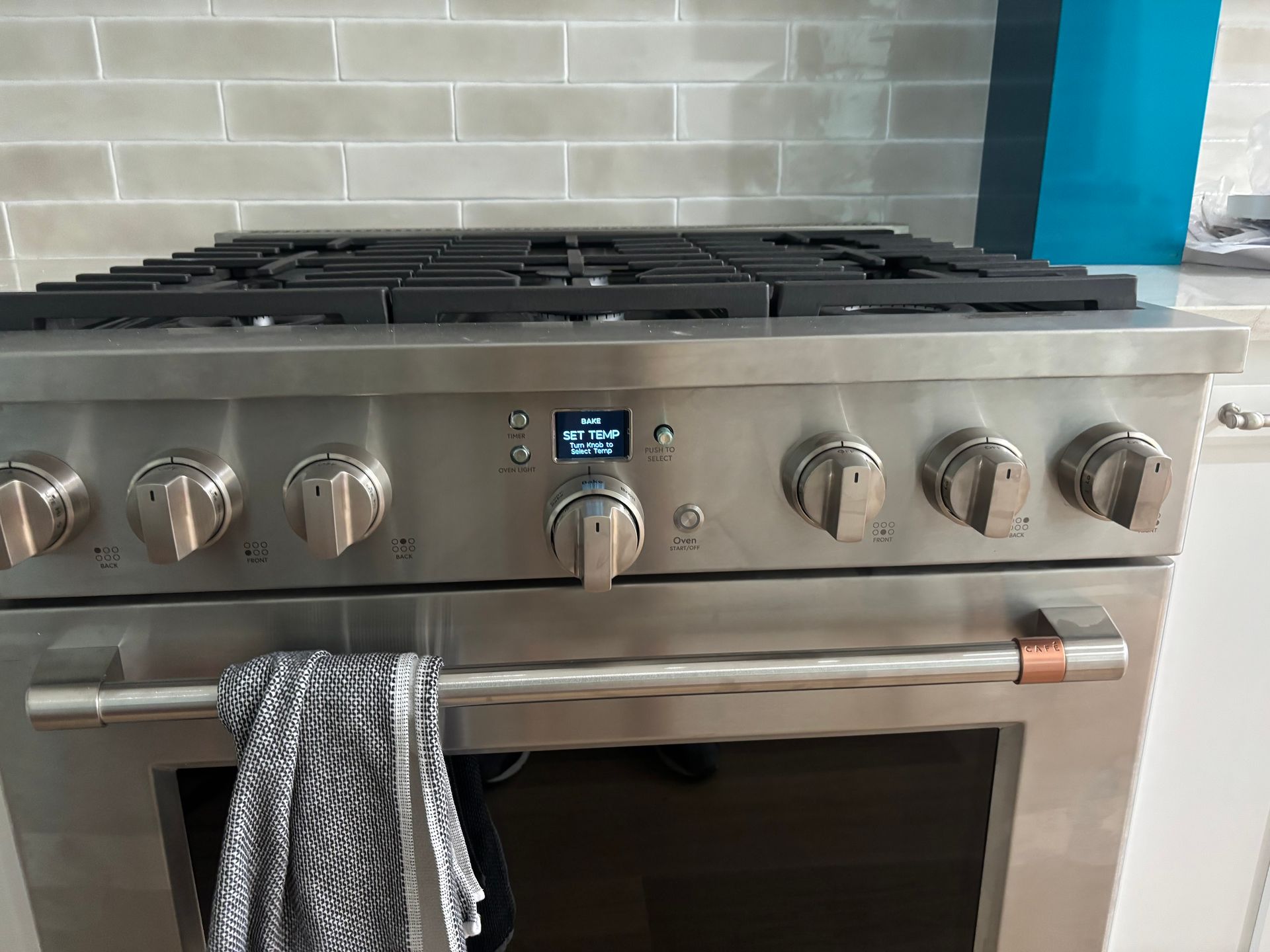 Stainless steel range with stovetop burners and oven below, knobs in front.