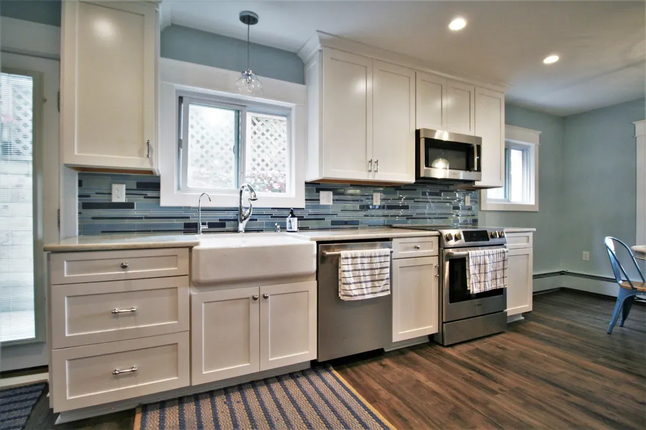 A kitchen with white cabinets and stainless steel appliances