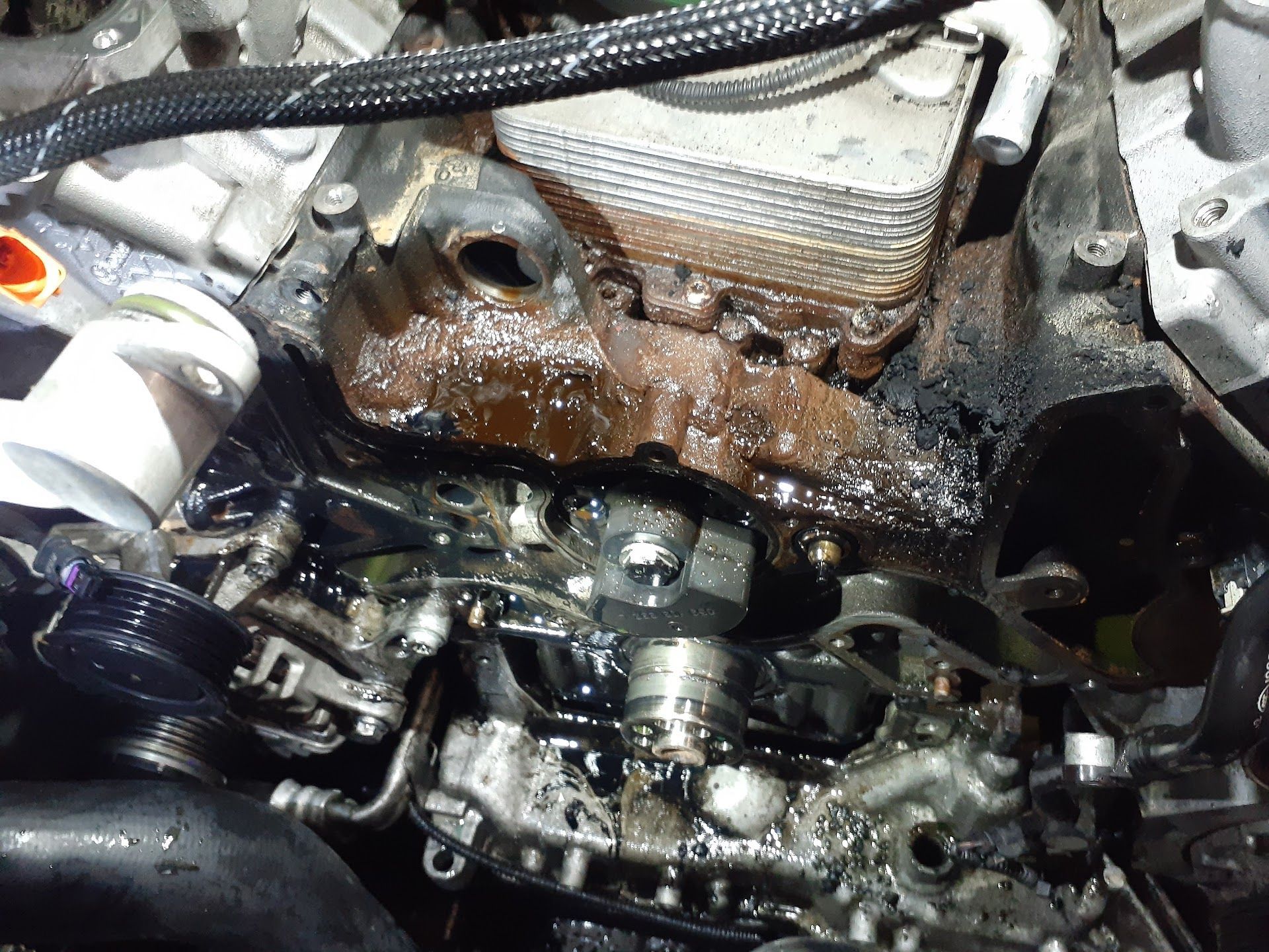 Engine block covered in oil, likely leaking; oily engine components visible | Action Service Center
