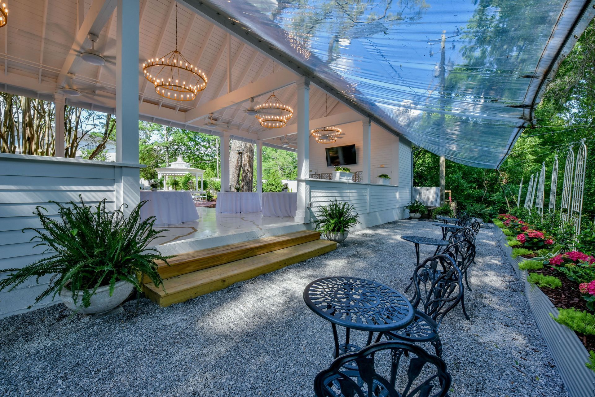 A screened in porch with rocking chairs and a red couch.