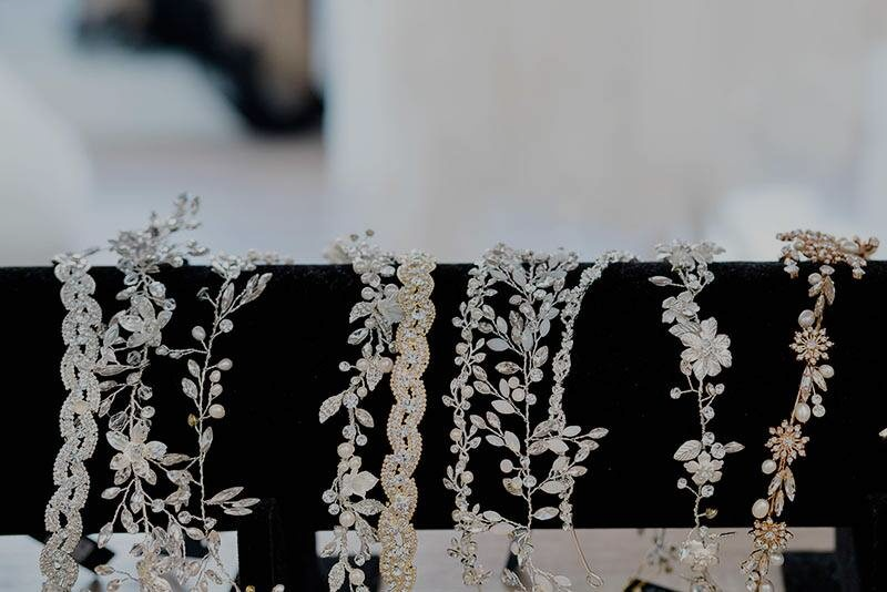 Silver and gold decorative headbands on display, featuring floral and vine designs.