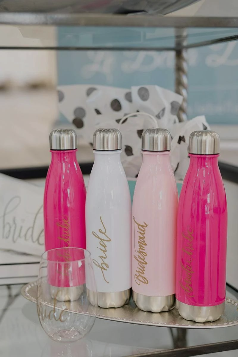 Four colorful water bottles, including a white 