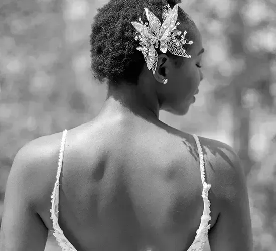 Bride in a dress, turned away, hair clip, natural light.