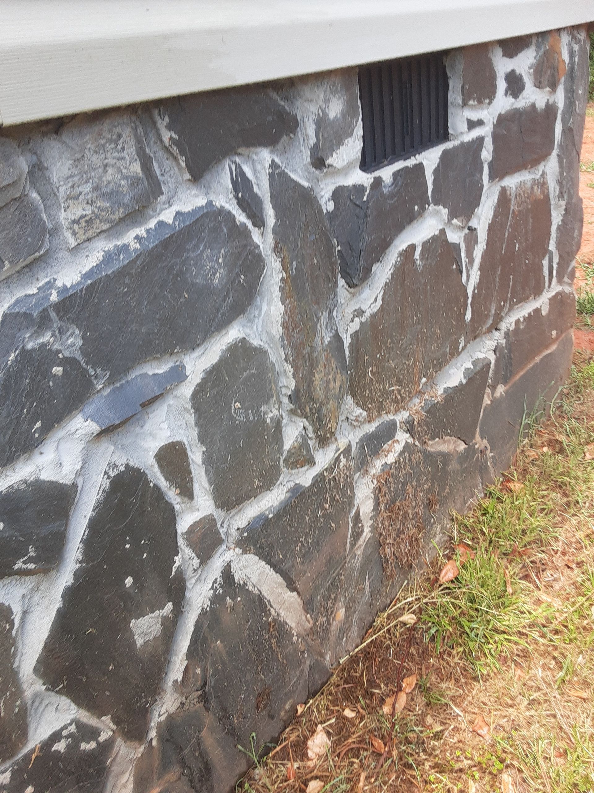 A stone wall with a hole in the middle of it