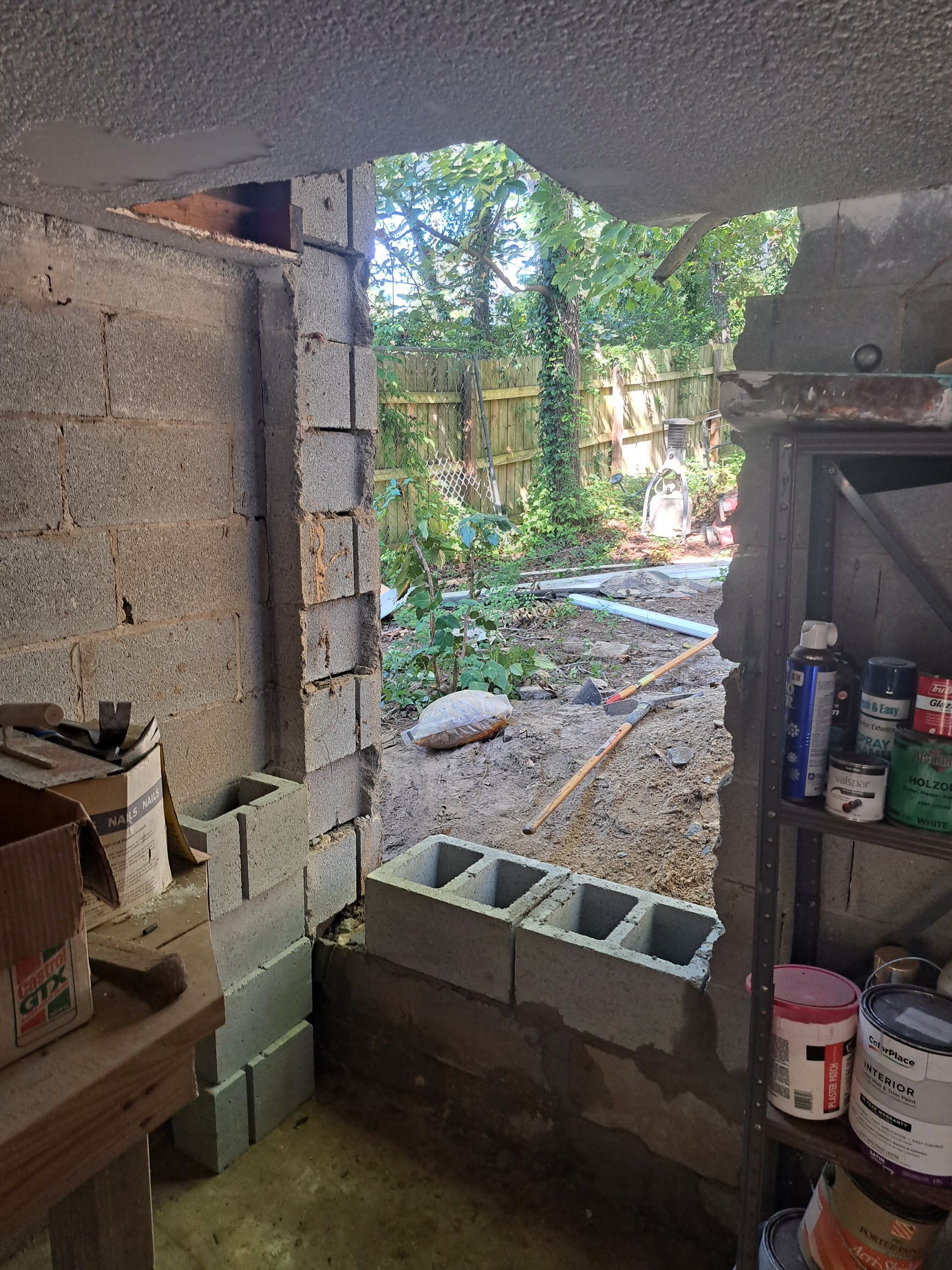 A room with a shelf and a window with a view of trees