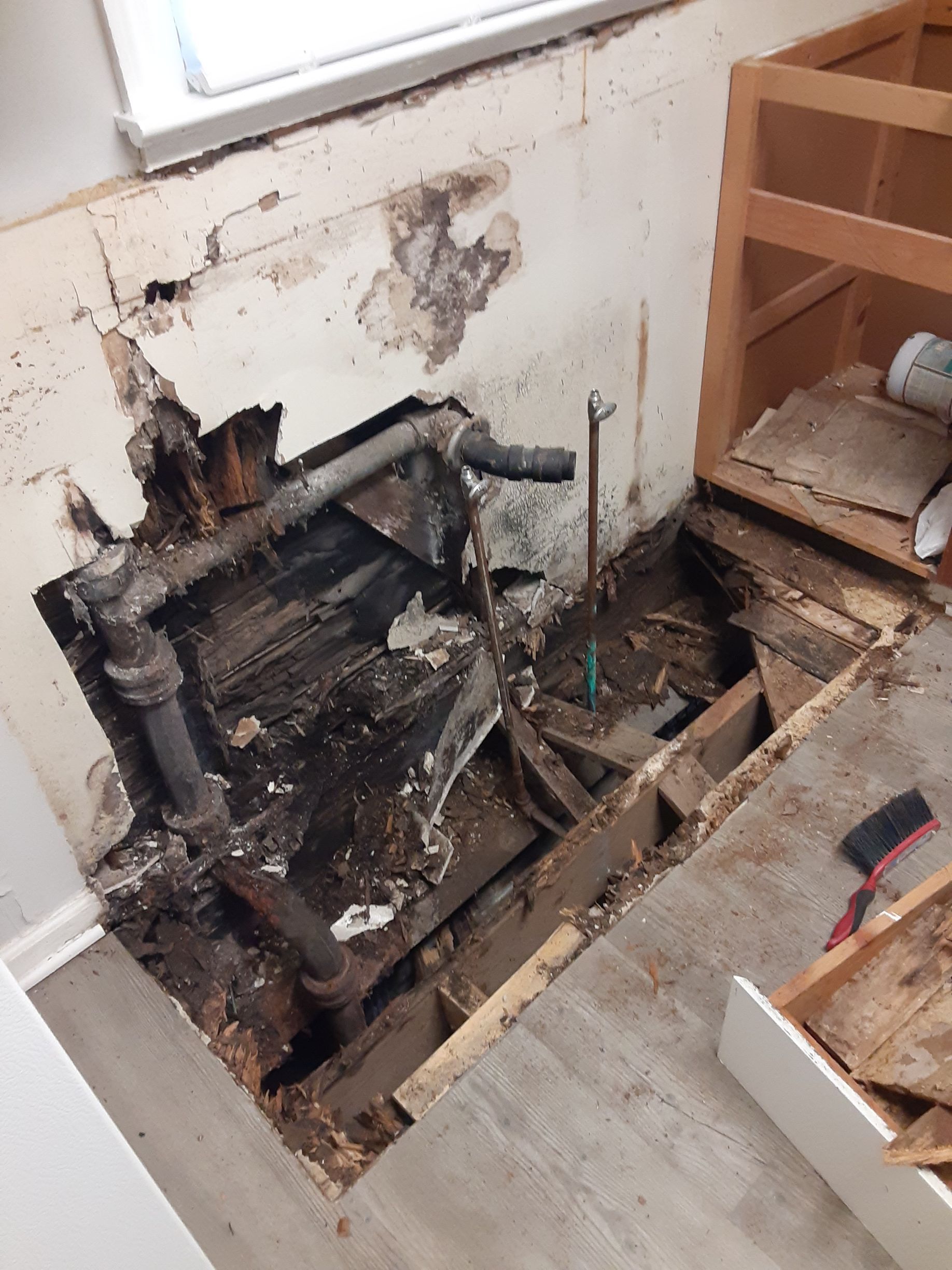 A hole in a wall with pipes coming out of it