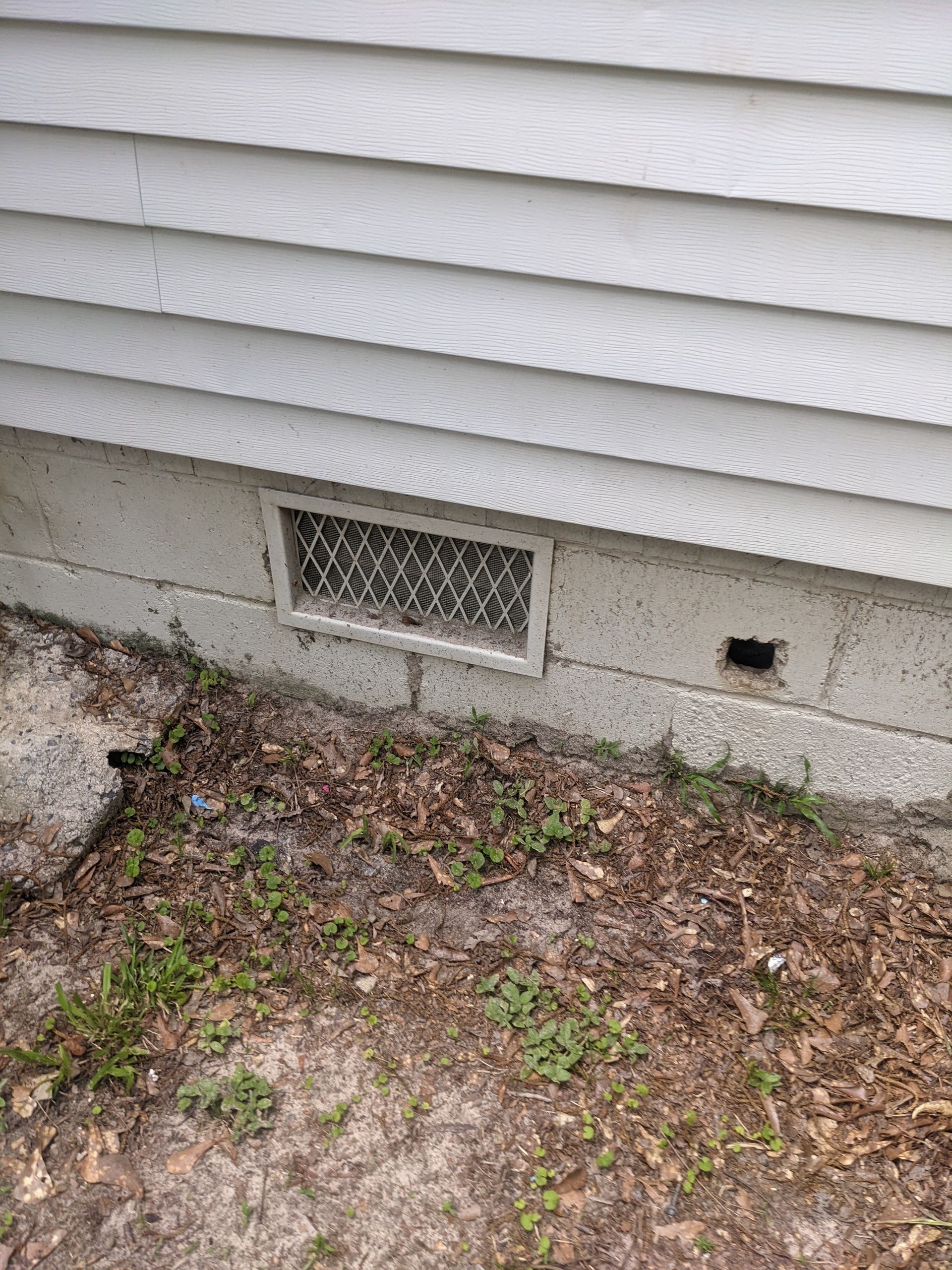 There is a vent on the side of a house.