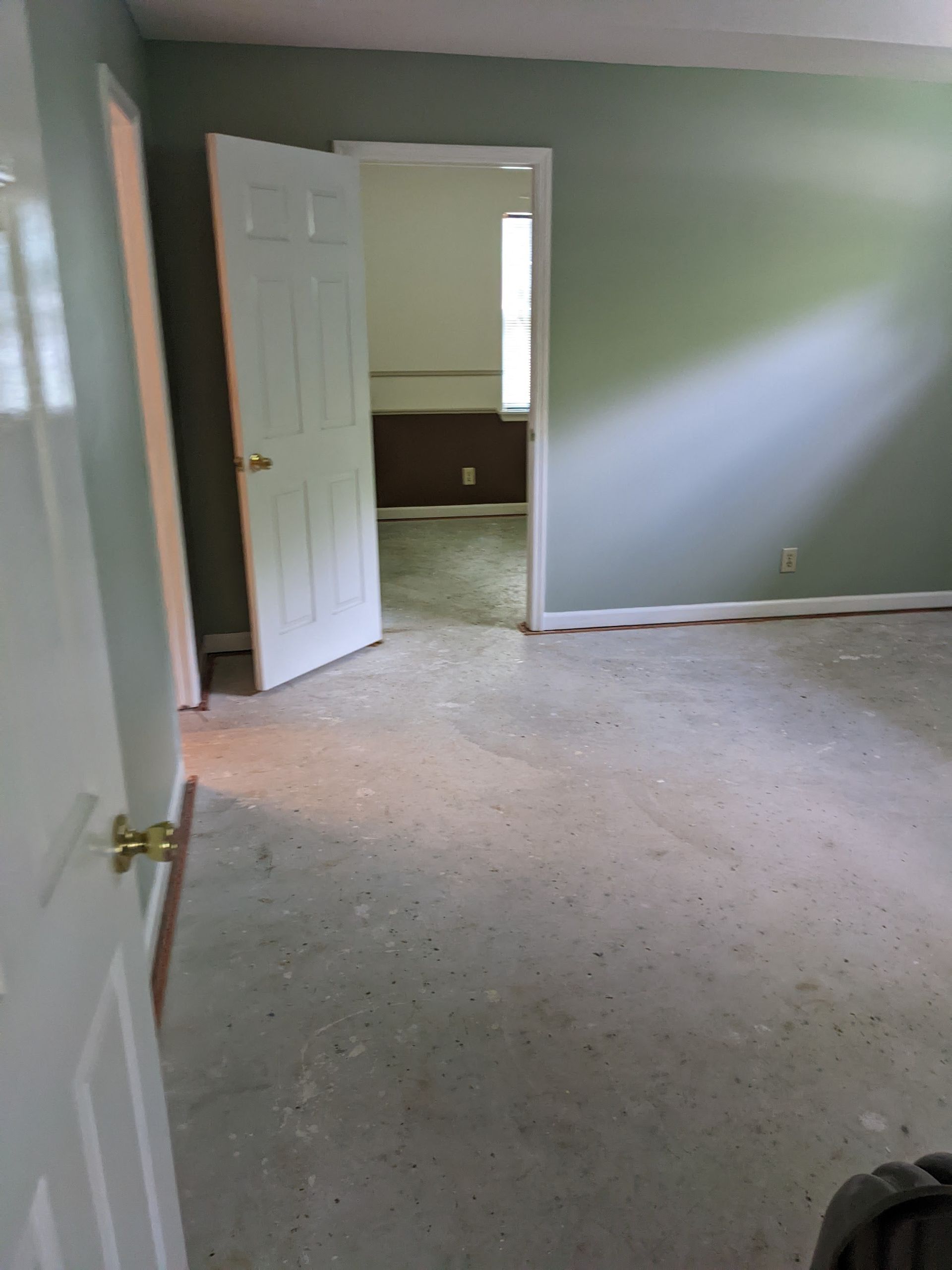 An empty bedroom with a door open and a carpeted floor.