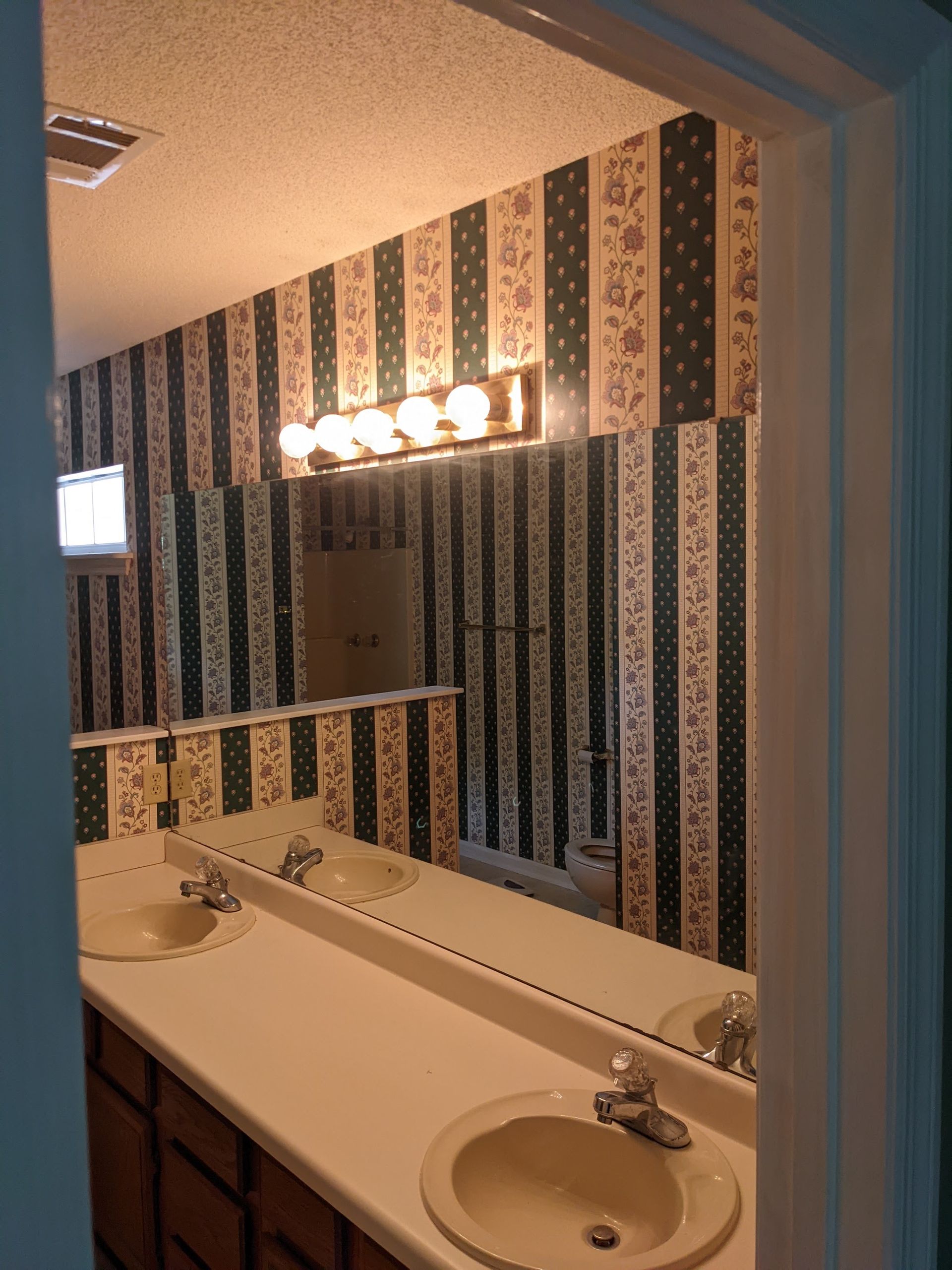 A bathroom with two sinks and a large mirror