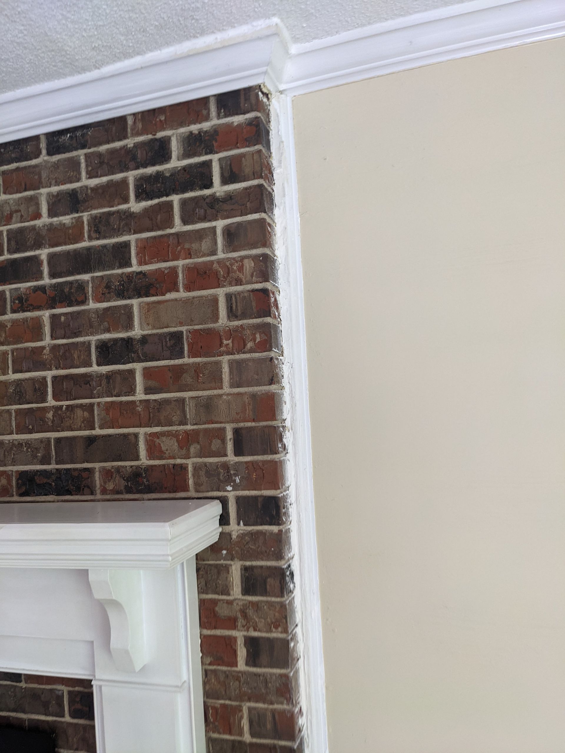 A fireplace with a brick wall and a white mantle