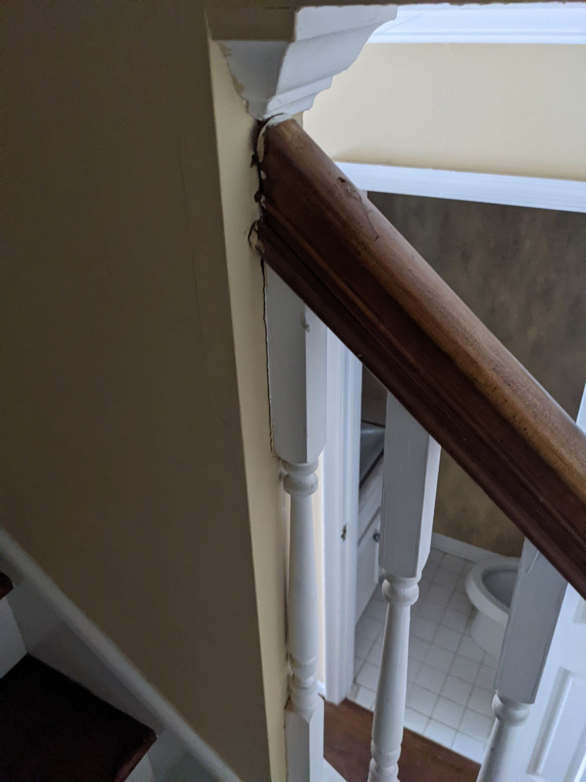 A staircase with a wooden railing and a white railing