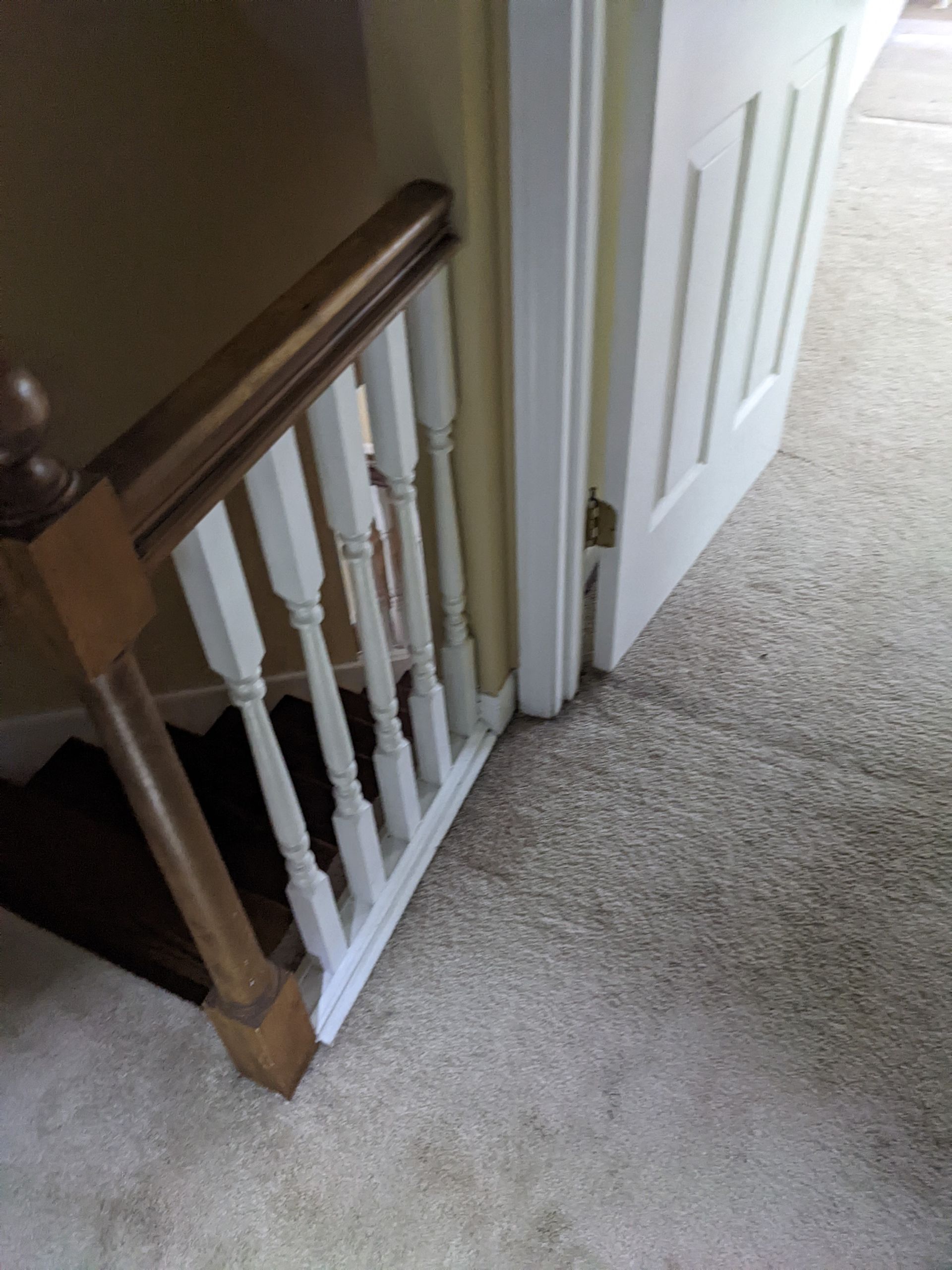 A staircase with a wooden railing and a white door.