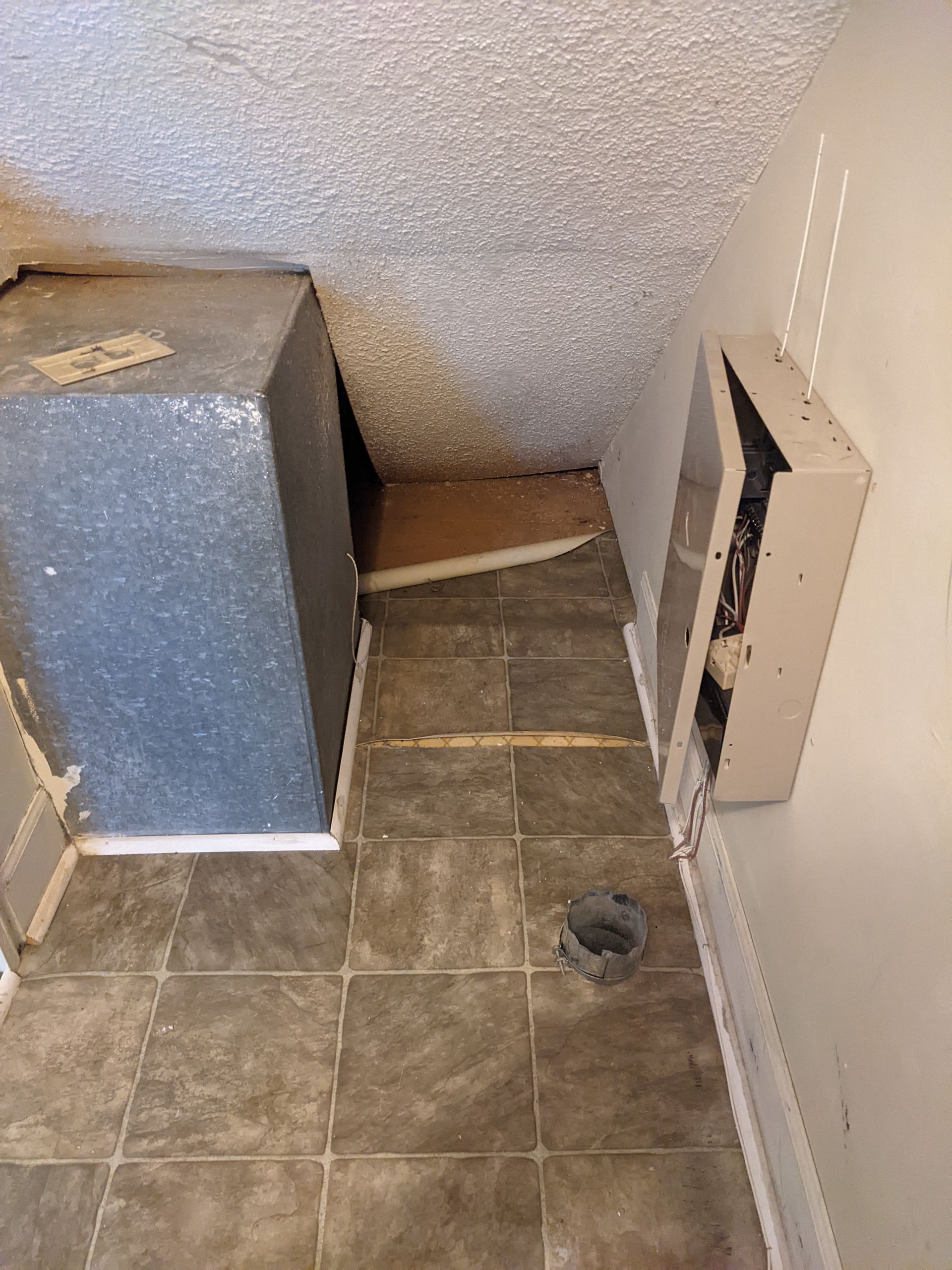 A room with a tiled floor and a box on the wall.