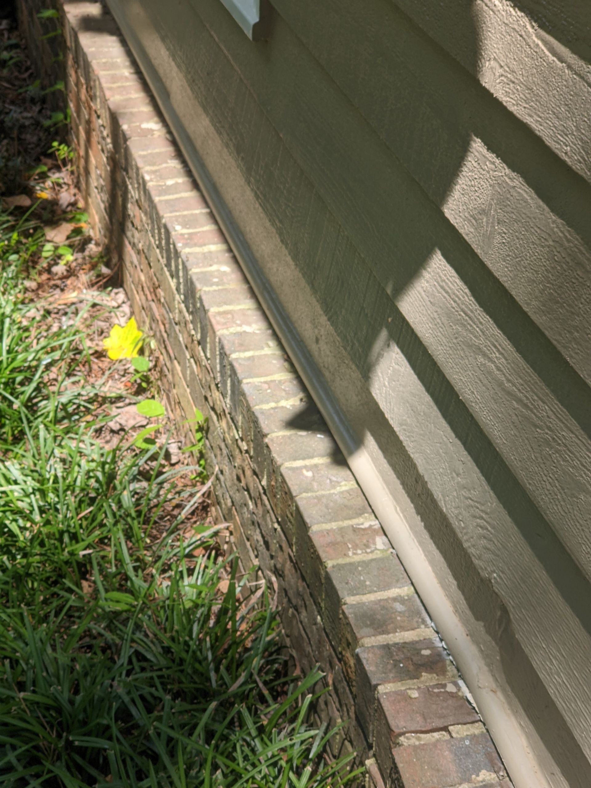 A close up of a brick wall next to a house.