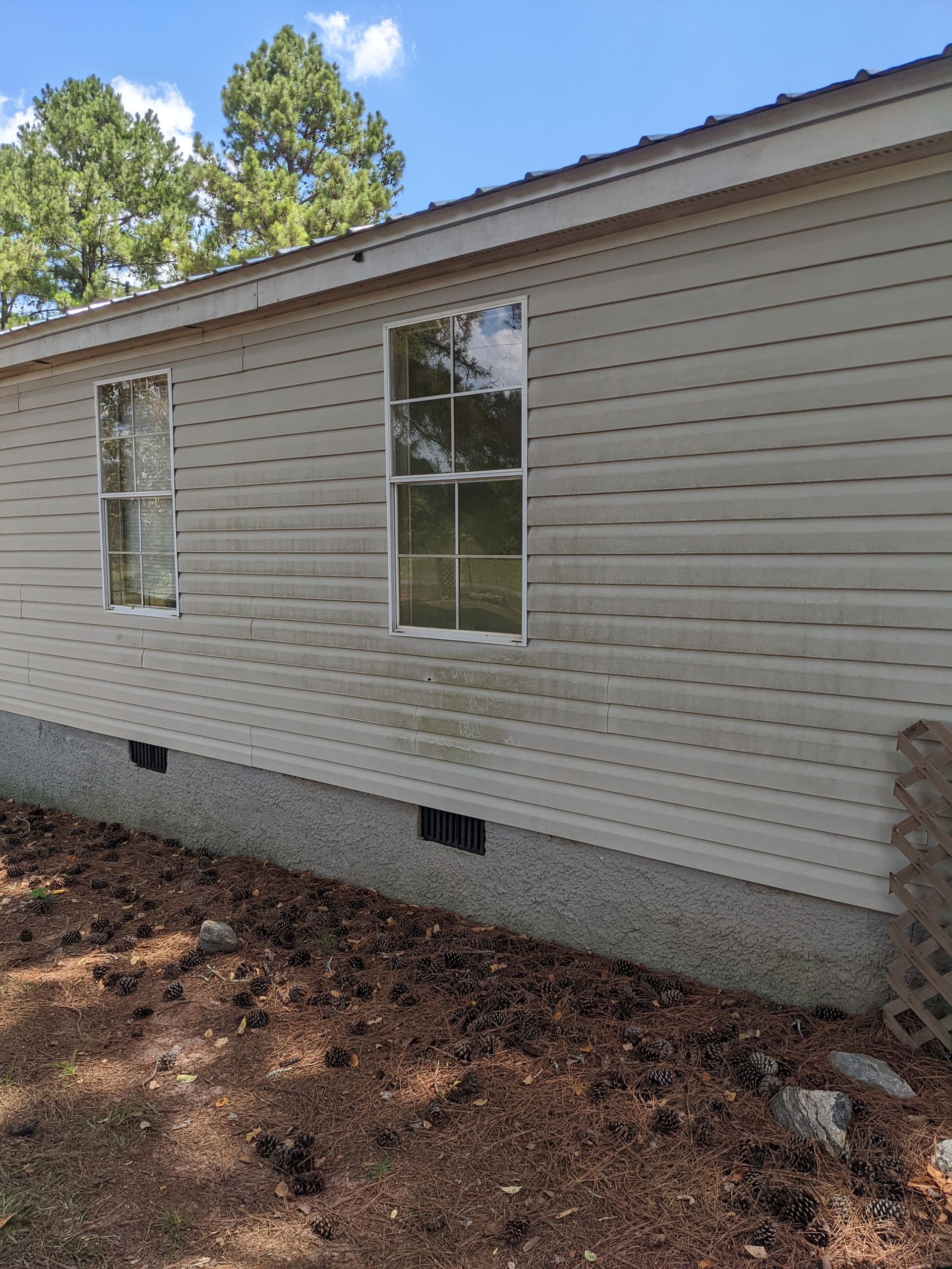 A mobile home with two windows on the side of it.