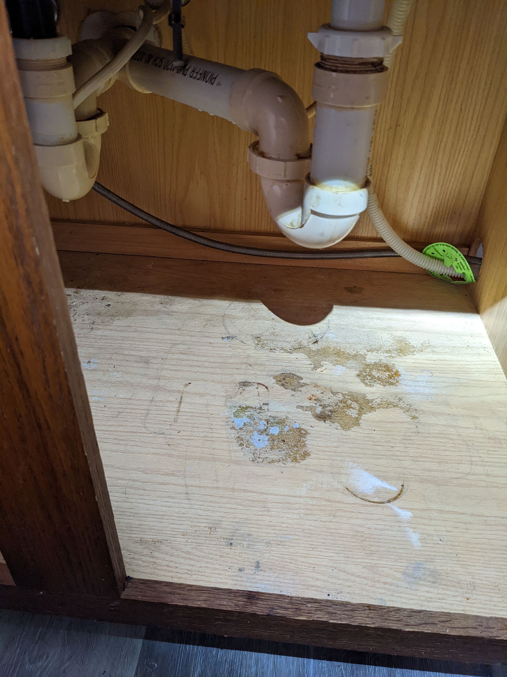 A kitchen sink with a lot of pipes underneath it.