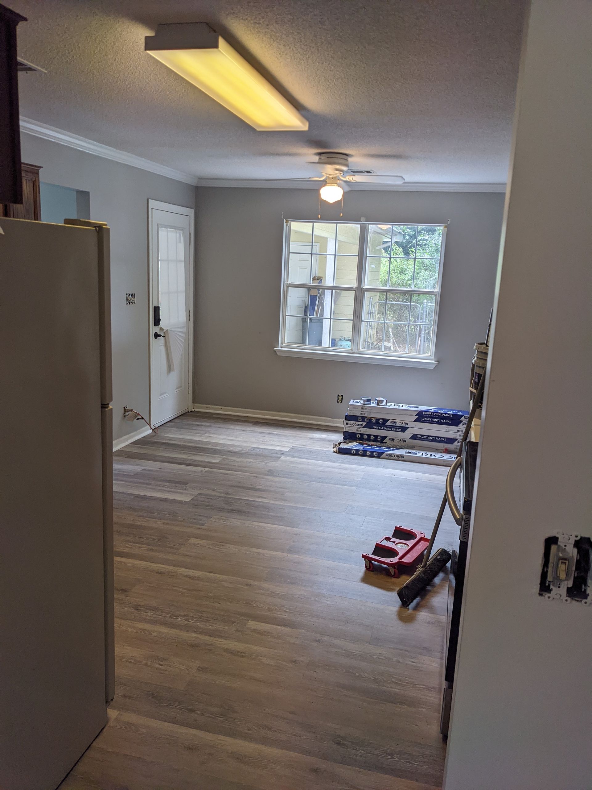 A living room with hardwood floors and a ceiling fan.