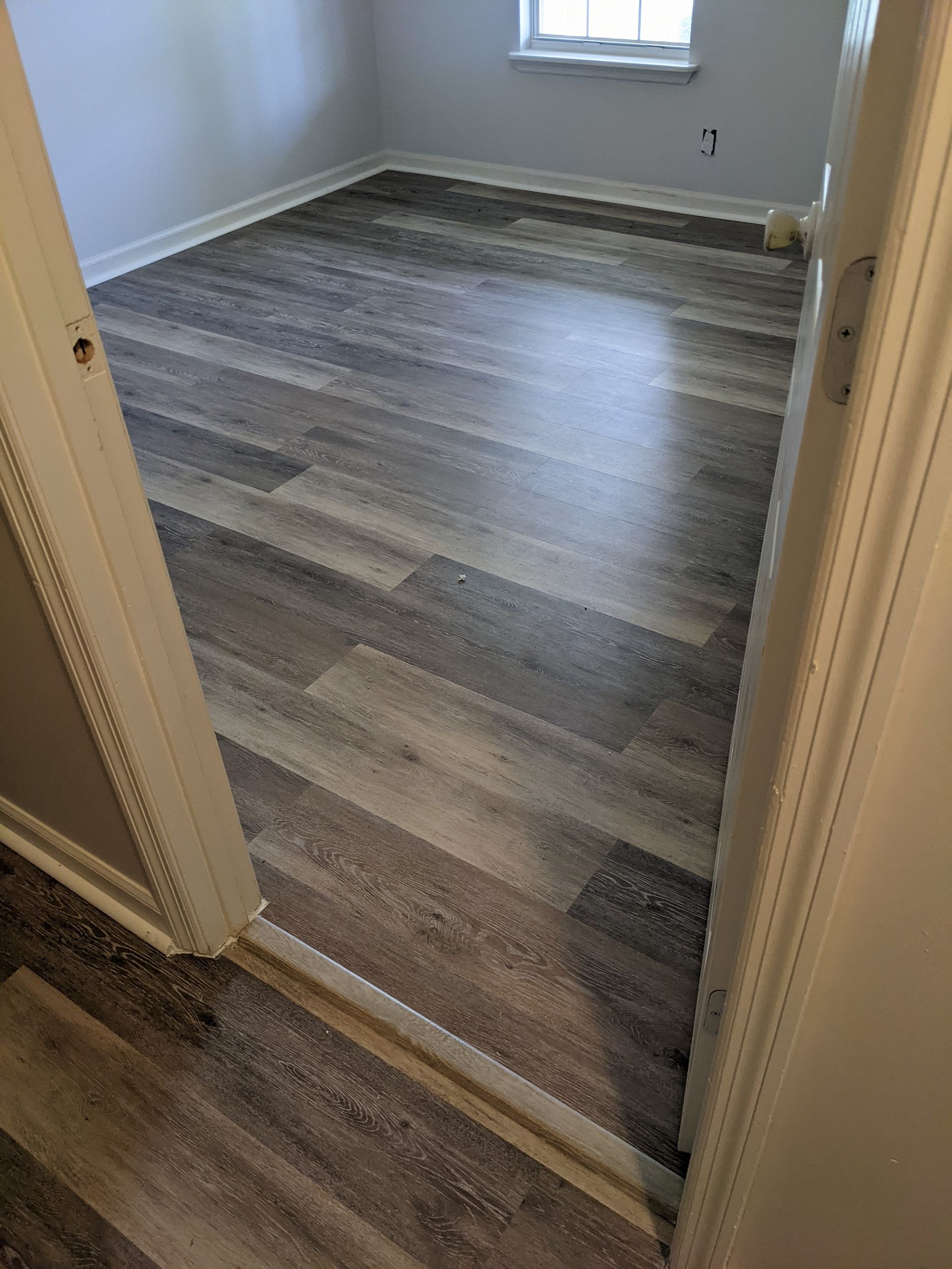 A room with a hardwood floor and a doorway leading to it.
