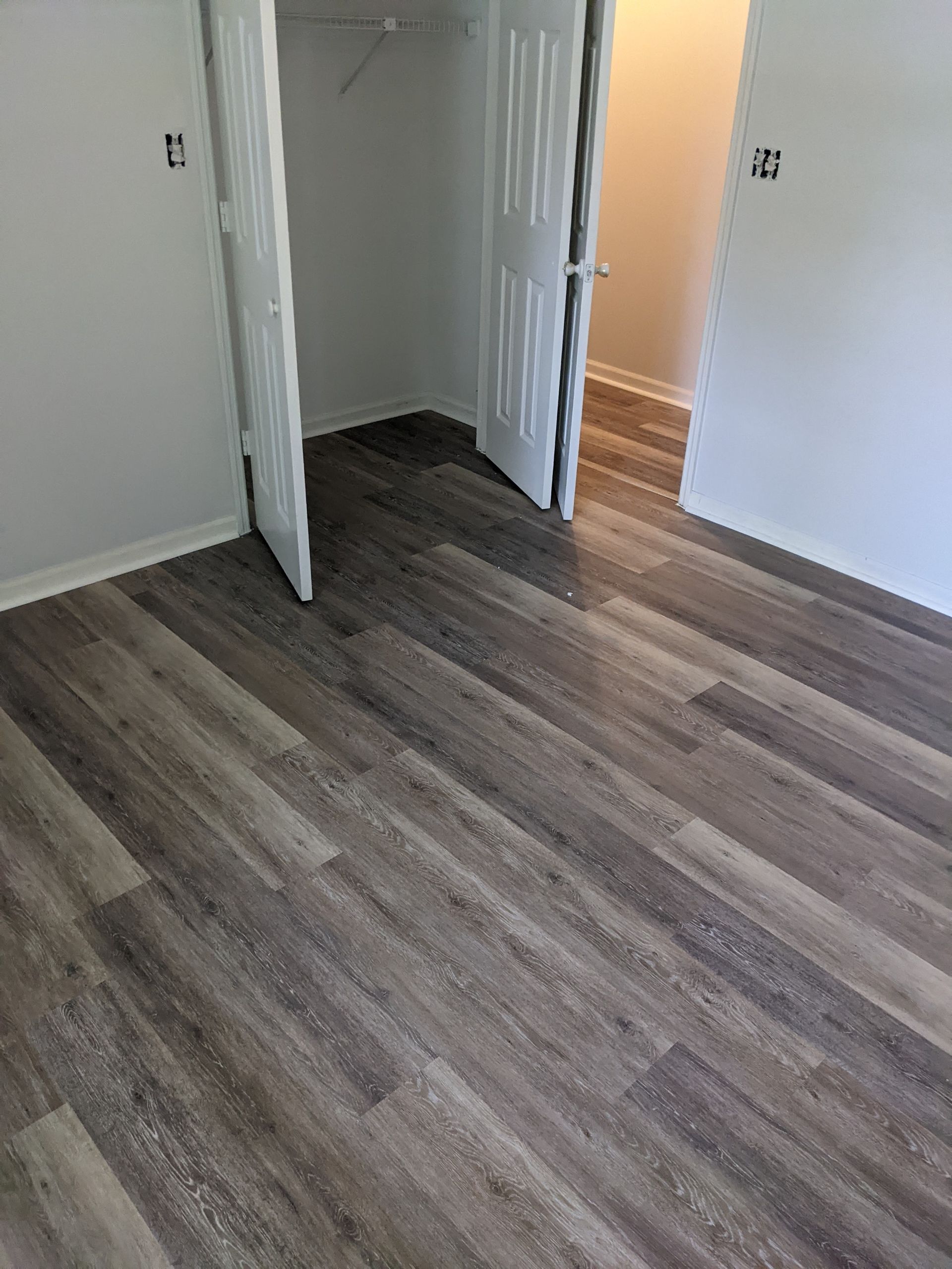 A bedroom with hardwood floors and a closet.